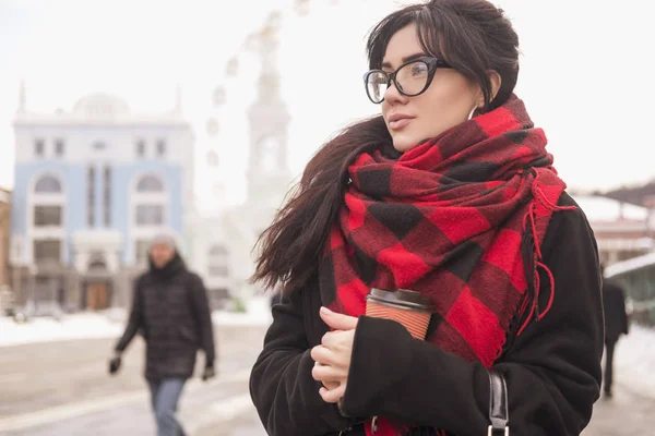 可爱的年轻白种黑发女学生在欧洲城市街道散步 她穿着拉丁大衣和格子红围巾 寒冷的冬天天气 — 图库照片