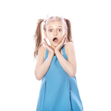 Beyaz izole zemin üzerinde mavi elbiseli Genç yedi yaşında esmer kız. Hayretle, sürpriz duygular yüzünde