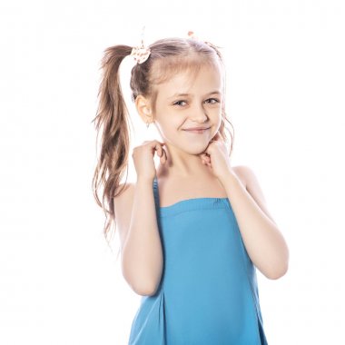 Beyaz izole zemin üzerinde mavi elbiseli Genç yedi yaşında esmer kız. Yüzünde gülümseme ve mutluluk duygular. Kız Bayan iki ön diş