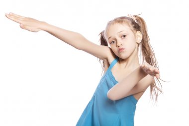 Beyaz izole zemin üzerinde mavi elbiseli Genç yedi yaşında esmer kız. Komik duygular yüzünde. O elleri ile jest yapma