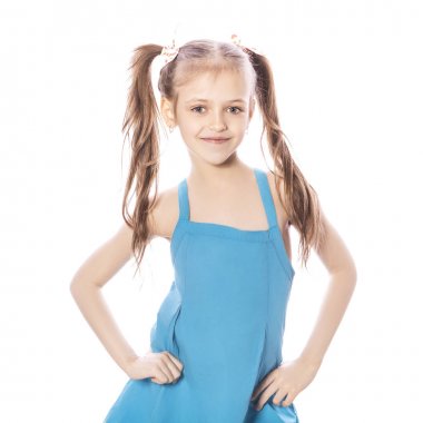 Beyaz izole zemin üzerinde mavi elbiseli Genç yedi yaşında esmer kız. Yüzünde gülümseme ve mutluluk duygular. Kız Bayan iki ön diş