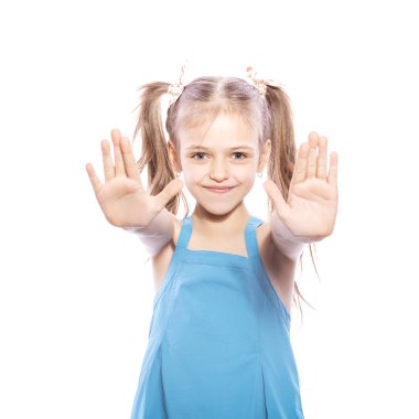 Beyaz izole zemin üzerinde mavi elbiseli Genç yedi yaşında esmer kız. O yüzündeki avuç içi jest elleri, gülümseyen ve mutluluk ve sevinç duygular kadar yapmak