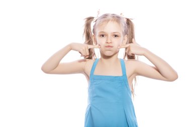 Beyaz izole zemin üzerinde mavi elbiseli Genç yedi yaşında esmer kız. Yüzünde onun yanakları, komik duygular üflüyor