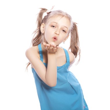 Beyaz izole zemin üzerinde mavi elbiseli Genç yedi yaşında esmer kız. O bir hava hareketi ile elleri ve dudakları öldürmek yaparken yüzündeki mutlu, neşeli duygular