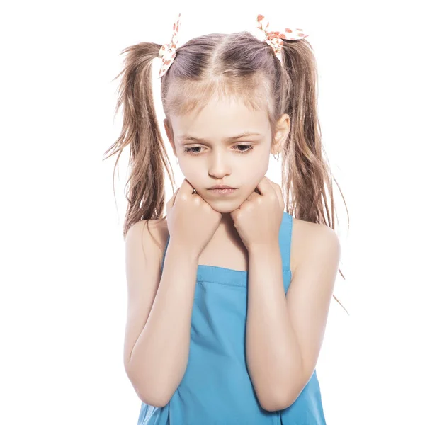 年轻的七岁的黑发女孩在蓝色礼服上的白色孤立的背景 她脸上的悲伤情绪 — 图库照片