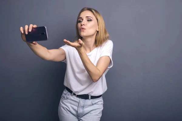 Caucasian woman in neutral casual outfit standing on a neutral g