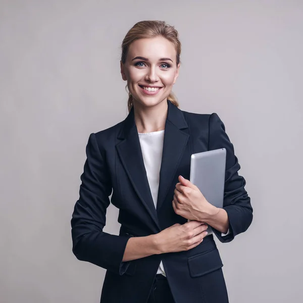 Kaukasische erwachsene Frau im Business-Outfit auf einem neutralen grauen Rücken — Stockfoto