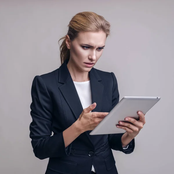 Kaukasische erwachsene Frau im Business-Outfit auf einem neutralen grauen Rücken — Stockfoto