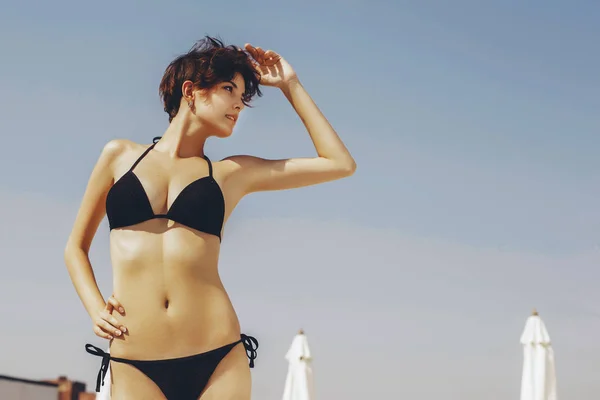 Beautiful brunette woman on the beach in pool alone relaxing in — Stock Photo, Image