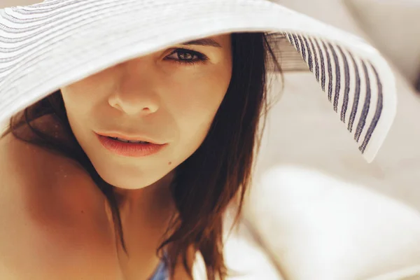 Mulher morena bonita na praia sozinha relaxando em um chapéu. S — Fotografia de Stock