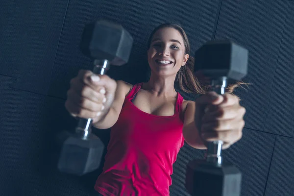Slim fit muscular morena ejercicio de mujer en el gimnasio, levantamiento de peso — Foto de Stock