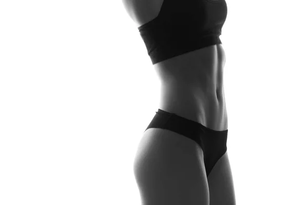ダンベルとセクシーなスリムフィット女性ボディ 筋肉質の腹部スポーツウェア 白で隔離された白黒画像 — ストック写真