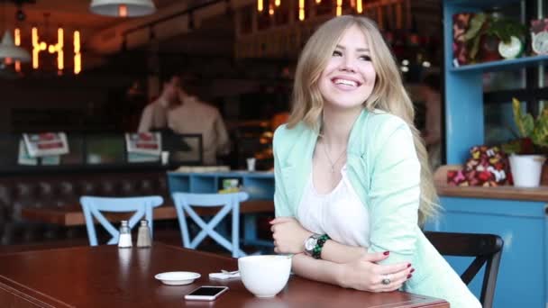 Vrouw in de zomer slim casual outfint zitten op een cafe terras, het drinken van koffie en het maken van selfie op haar telefoon. Sexy schattig glimlachen blond poseren en flirten op camera — Stockvideo