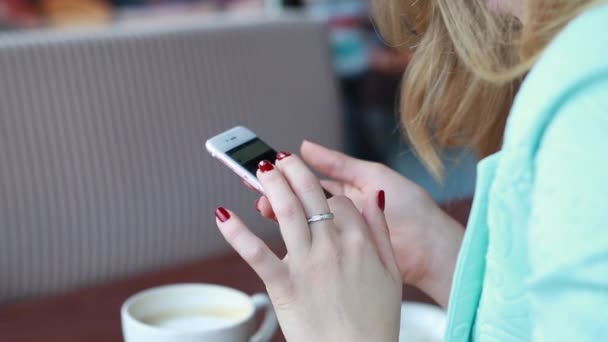 Vrouw in de zomer slim casual outfint zitten op een cafe terras, het drinken van koffie en werken in sociale media op haar telefoon. Sluiten van haar handen en telefoon — Stockvideo