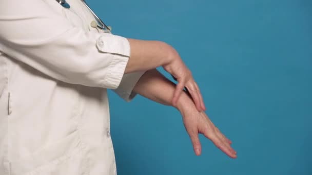 高齢者Caucasian医師女性でホワイトコート上の青の背景 — ストック動画