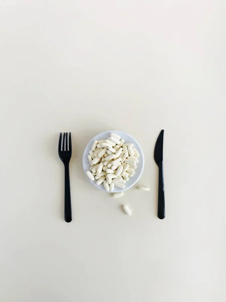 Fehér Tabletták Feküdnek Egy Tányéron Evőeszközök Mellett Kés Villa — Stock Fotó