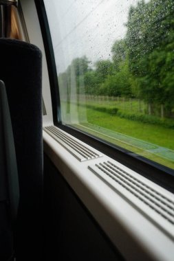 Hareket eden bir trenin camında yağmur damlaları                               