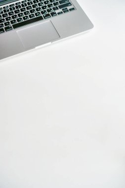 kahve fincanı ve gri laptop beyaz arka planda masanın üstünde.