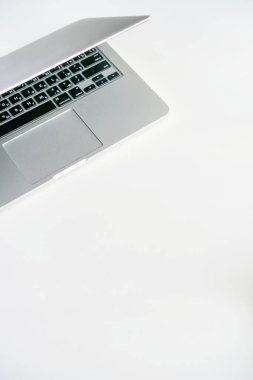 kahve fincanı ve gri laptop beyaz arka planda masanın üstünde.