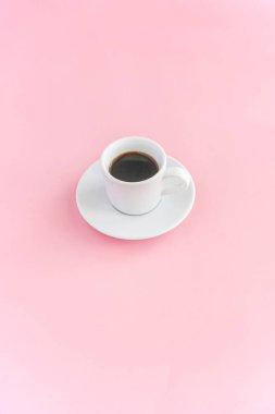 Kahve fincanı ve pembe arkaplanda pembe şekerlemeler.
