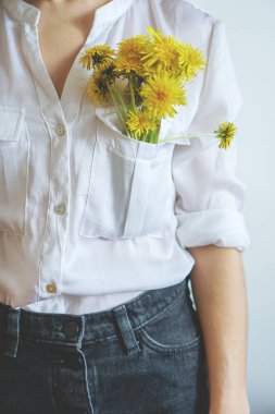 Kız elinde sarı karahindiba tutuyor.