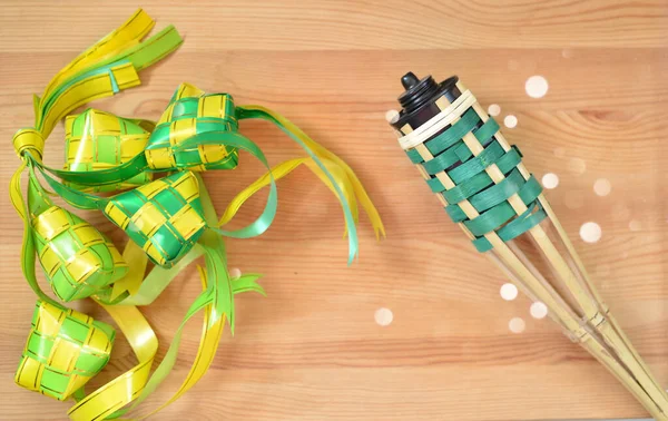 Hari Raya kavramı için pelita / yağ lambalı ketupat Asya yemekleri ahşap arka planda izole edilmiştir..
