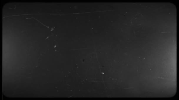 Screen of a Retro TV with scratches and damage. Black and white screen with rounded edges and damaged film tape. — Stok video