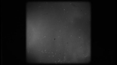 Screen of a Retro TV with scratches and damage. Black and white screen with rounded edges and damaged film tape.