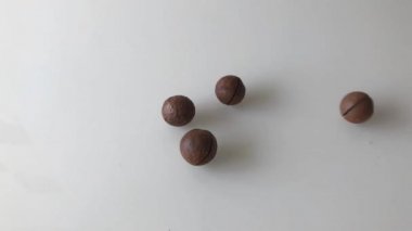 Masaya dağılmış Macadamia fındıkları ve olgun demirhindi meyveleri. Yavaş çekim.