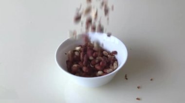 Fıstıklar masanın üzerine cam kaseye dökülür. Yavaş çekim.