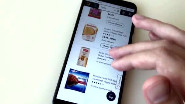 Мужчина заказывает макароны в интернет-магазине, используя смартфон. Выбор товаров в интернет-магазине с доставкой на дом . — стоковое видео