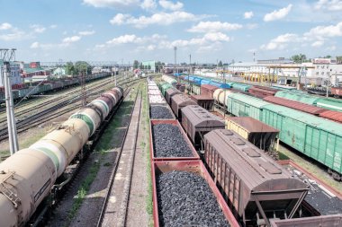 Öndeki vagonlarda bir depoda yük vagonları kömürle dolu.