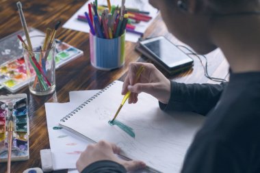 - Sanat. Yaratılış. Yakın plan. Kız albümde suluboya resim çiziyor.