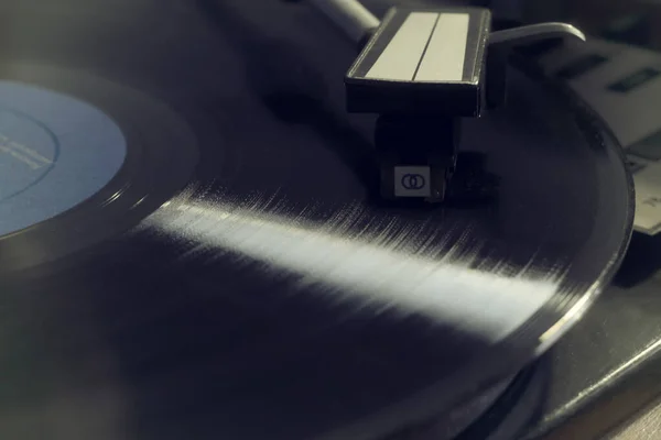 Retro lemezjátszó bakelitlemez lejátszása kék címkével, filmhatás — Stock Fotó