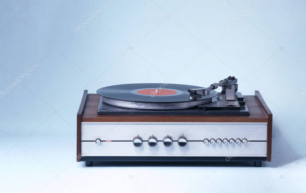 Vintage record player and vinyl record on a blue background. Retro style