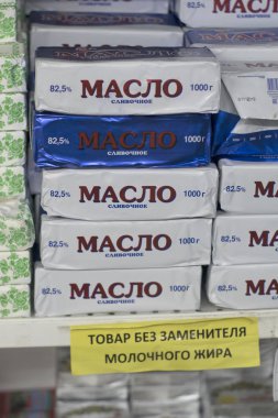 Packs of butter on a store counter with inscriptions in Russian clipart