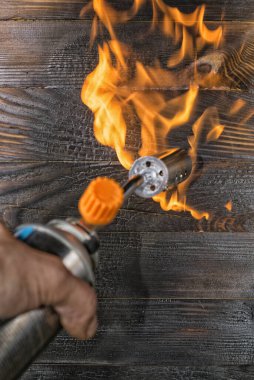 Gaz ocağıyla tahtaları fırçalamak. Yanan tezgah