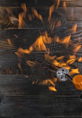 Gaz ocağıyla tahtaları fırçalamak. Yanan tezgah