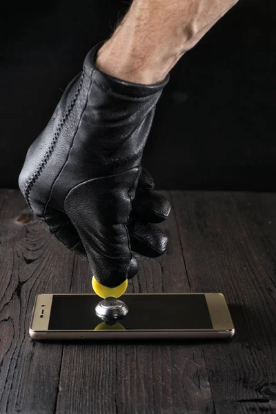 Smartphone mit Schloss, Datenschutzkonzept, Verschlüsselungsschlüssel-Sicherheit. zuverlässiger Schutz vor Hackerangriffen. — Stockbild Die Hand eines Angreifers in einem schwarzen Handschuh öffnet das Schloss eines Smartphones mit einem Schlüssel. das Konzept des Schutzes persönlicher Daten. Schutz durch Verschlüsselungsschlüssel. — Stockfoto
