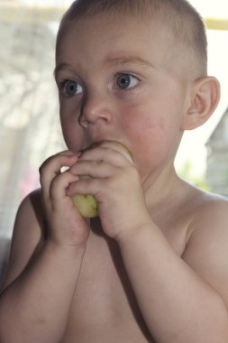 Koca bir salatalık suyu yiyen tatlı sarışın bebek yanaklarından aşağı akıyor.