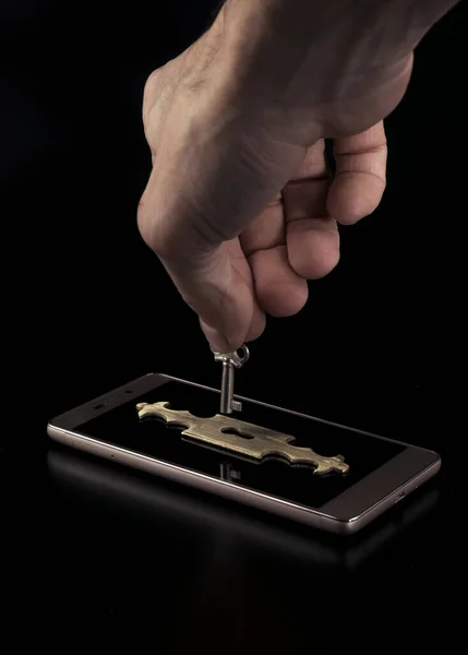 Smartphone mit Schloss, Datenschutzkonzept, Verschlüsselungsschlüssel-Sicherheit. zuverlässiger Schutz vor Hackerangriffen. — Stockbild Die Hand eines Angreifers entriegelt ein Smartphone mit einem Schlüssel. das Konzept des Schutzes persönlicher Daten. Schutz durch Verschlüsselungsschlüssel. — Stockfoto