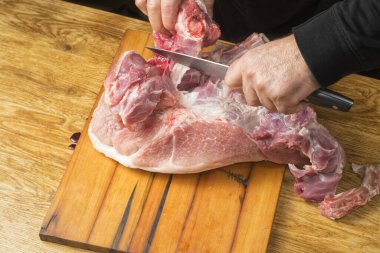 Aşçı büyük bir bıçaklı domuz jambonunu kesiyor..