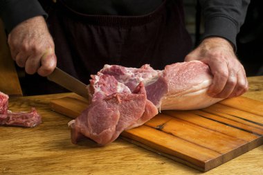 Aşçı büyük bir bıçaklı domuz jambonunu kesiyor..