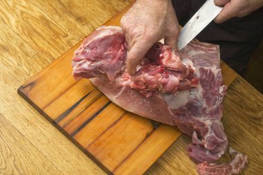 Aşçı büyük bir bıçaklı domuz jambonunu kesiyor..