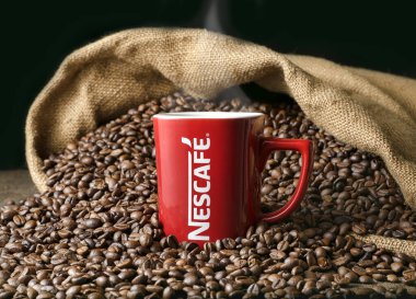 Nescafe 'nin kırmızı bardağı, kahve çekirdeklerinin arka planında. Durgun hayat. Rusya Federasyonu 'ndan 2020 Kursk