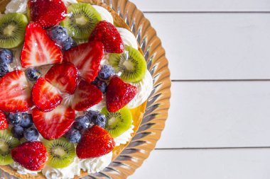 Pasta krema, çilek, yaban mersini ve kivi ile üstten görünüm Beyaz ahşap tablo