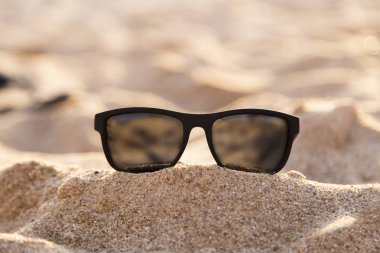 resim Kum Plajı üzerinde siyah güneş gözlüğü 