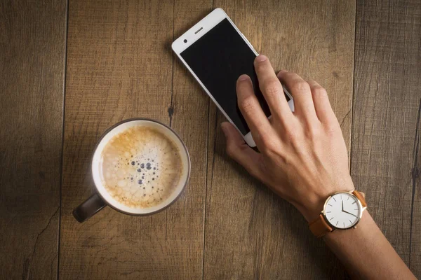 Mão Masculina Com Relógio Pulso Segurando Smartphone Xícara Café Mesa — Fotografia de Stock