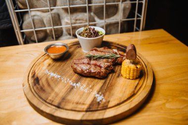 Tahta üzerinde sebzeli, sulu biftek.