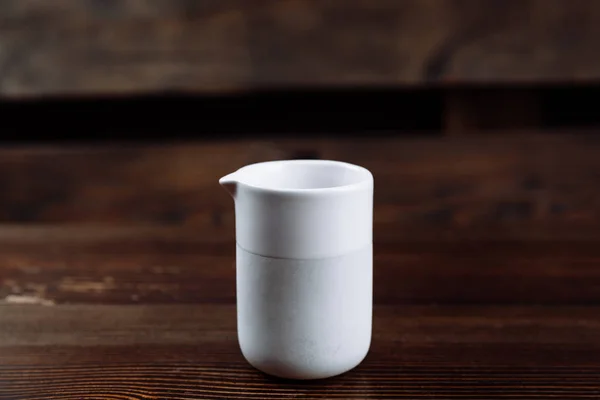 Tasse de lait de couleur blanche sur un fond en bois . — Photo